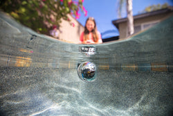 A young girl drives a Sphero BOLT through water in the backyard.