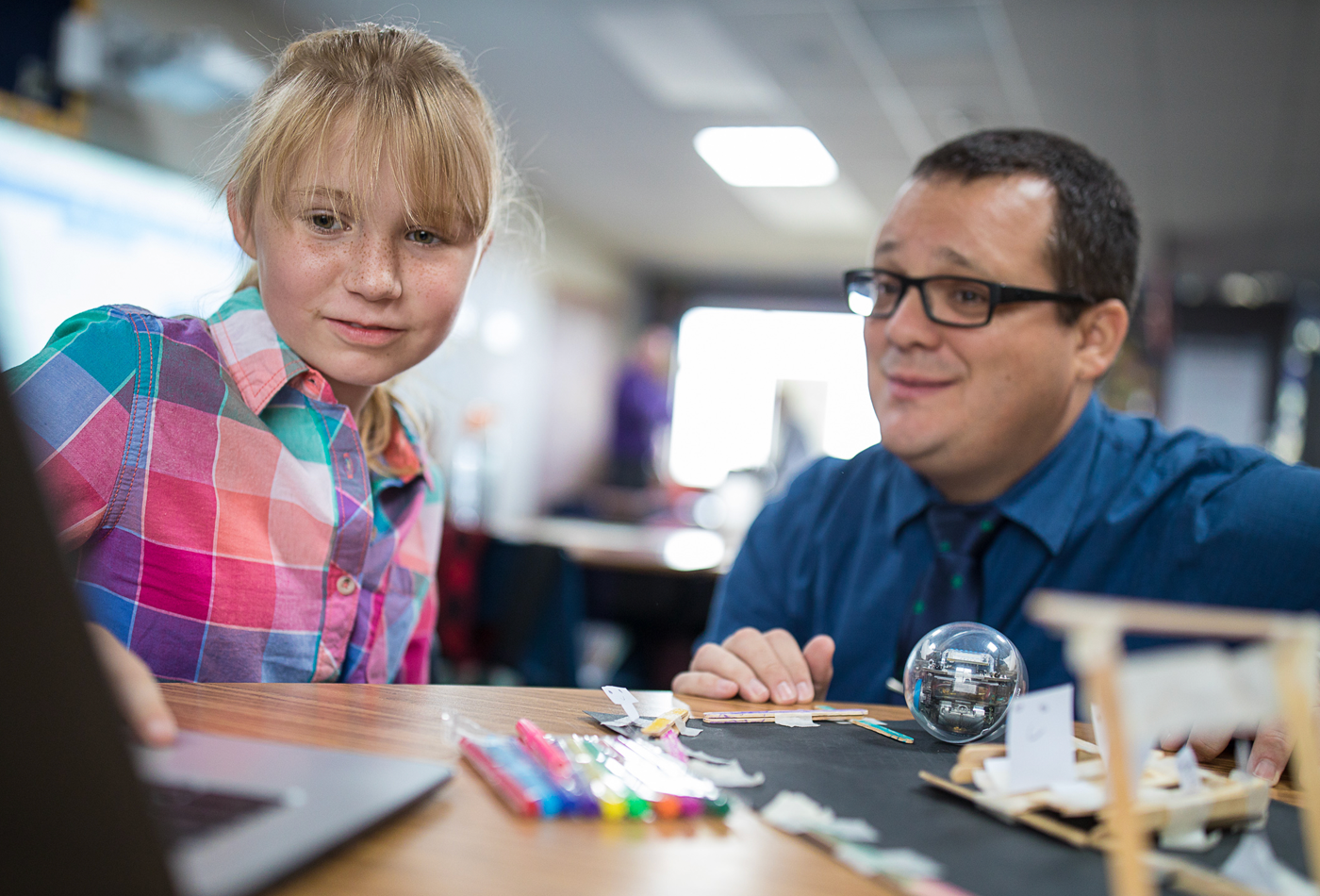 A student and an educator working with the Sphero BOLT programmable learning robot system.