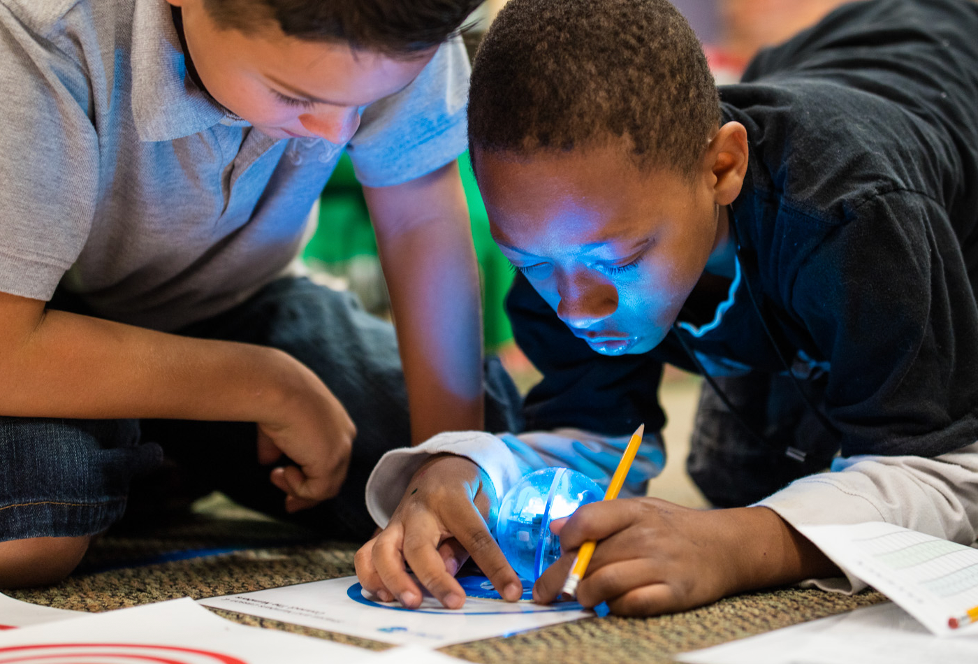 Two young boys coding Sphero BOLT robot for kids.