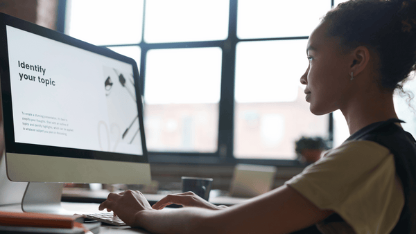 A female student works at her computer using an AI tool to assist in her project.