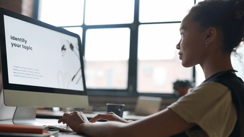 A female student works at her computer using an AI tool to assist in her project.