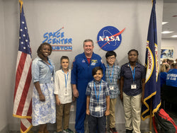 Students posing for picture with NASA astronaut. 