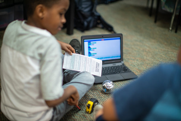 This image shows a student learning the engineering design process with programmable robots like Sphero BOLT. 