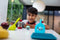A boy drives his Sphero Mini across the kitchen table through obstacles created out of cooking utensils.