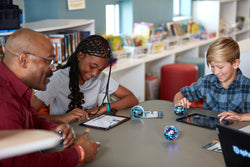 A teacher and two students work with a coding robot Sphero BOLT+ showing how robots can support differentiated instruction in the classroom.