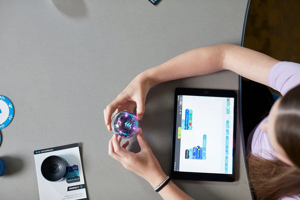 A student programs a BOLT+ robot in the Sphero Edu App on a tablet.