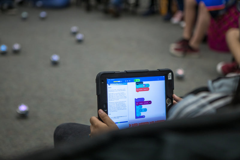 A student uses block coding for kids in the Sphero Edu app to program a Sphero BOLT robot.