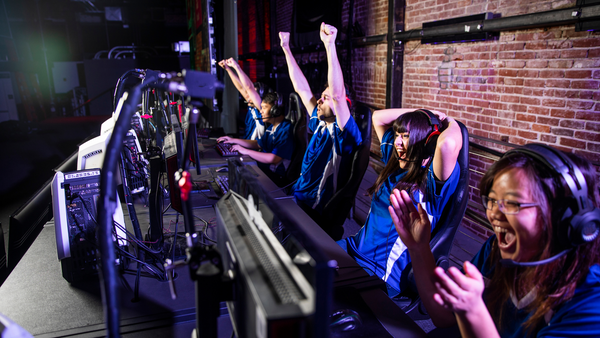 A team of esports players cheers at their computers after winning a challenge. Esports and Education can help each other make learning fun and engaging for a variety of students.