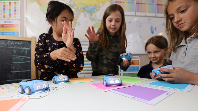 Four young kids program and play with Sphero indi in their classroom.