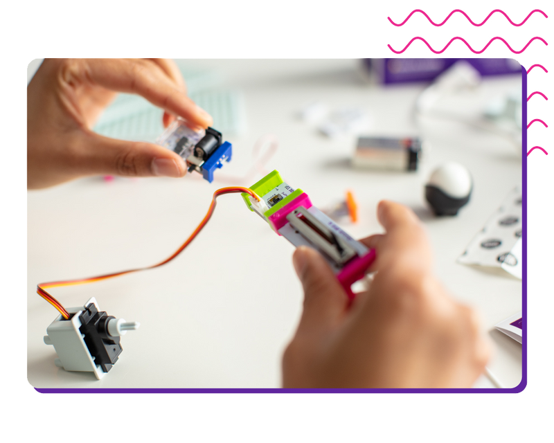 Hands snapping littleBits circuits together.