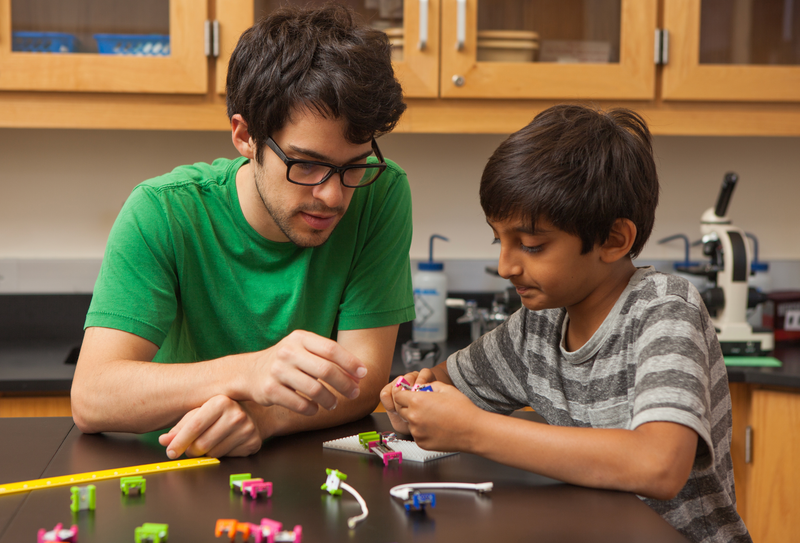 Kid learning littleBits engineering from teacher.