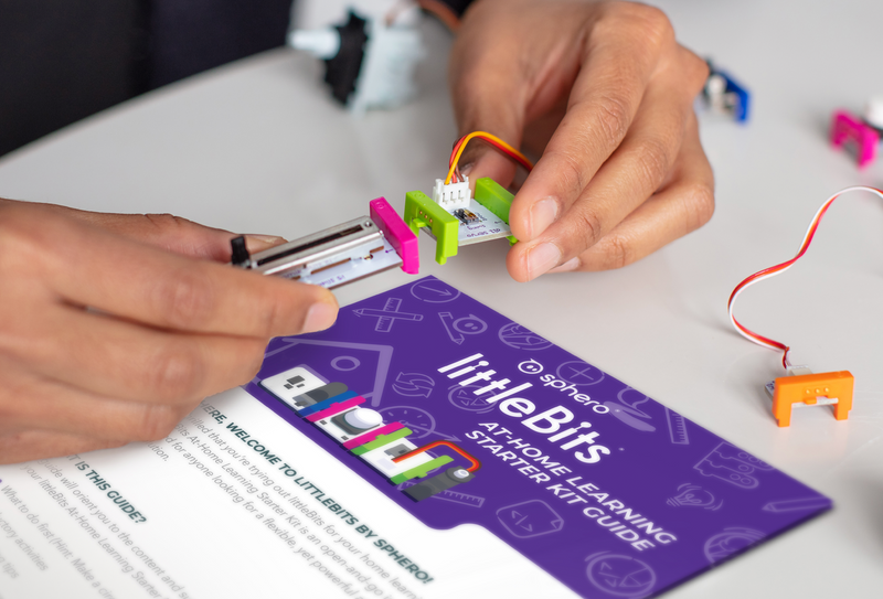 Person using littleBits engineering parts with at-home learning guide.