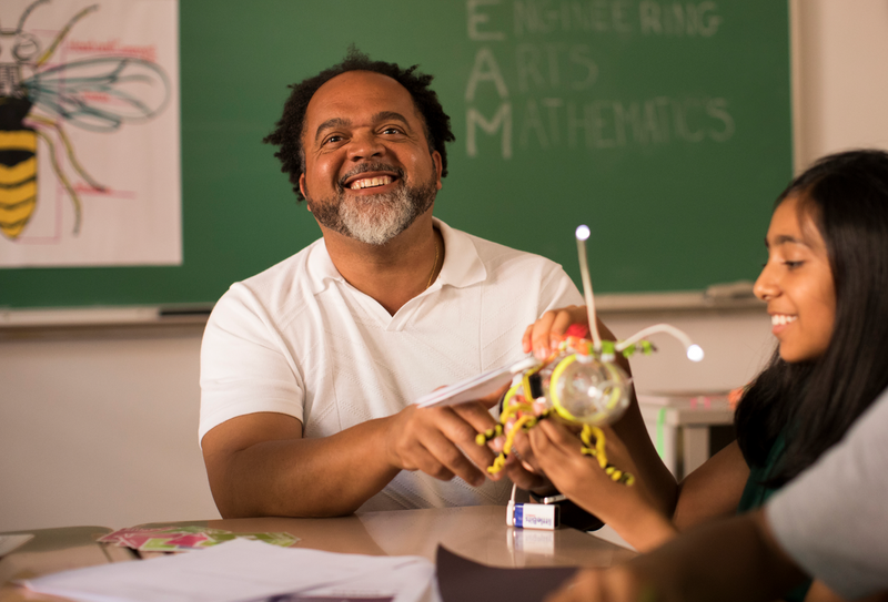 Happy teacher using littleBits in the classroom.