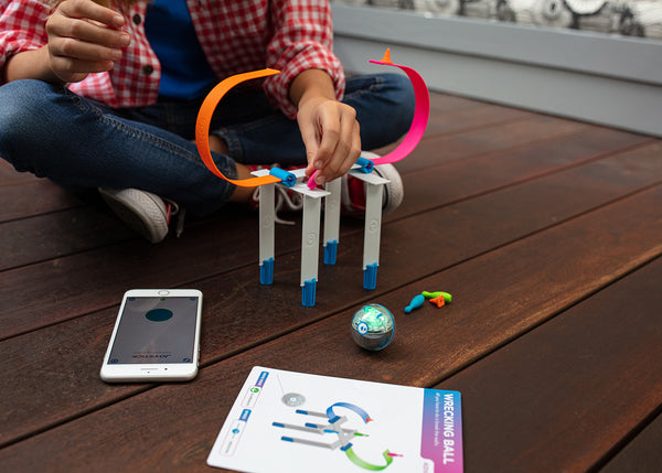 A kid building a tower out of the Sphero Mini Activity Kit. 