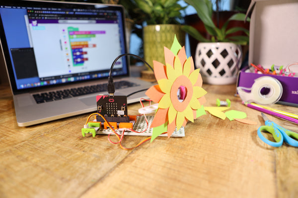 micro:bit invention with yellow sunflower and laptop in the background.