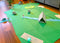  Mini golf course made out of construction paper and household items in a living room.