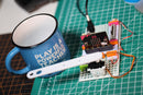 micro:bit clock invention with littleBits arm tapping a coffee mug.